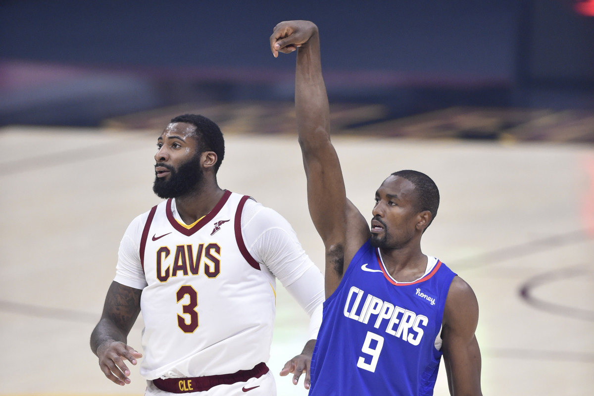 Feb 3, 2021; Cleveland, Ohio, USA; LA Clippers center Serge Ibaka (9) reacts to his three-point basket beside Cleveland Cavaliers center Andre Drummond (3) in the first quarter at Rocket Mortgage FieldHouse. Mandatory Credit: David Richard-USA TODAY Sports